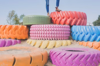Colorful tires stacked in a backyard